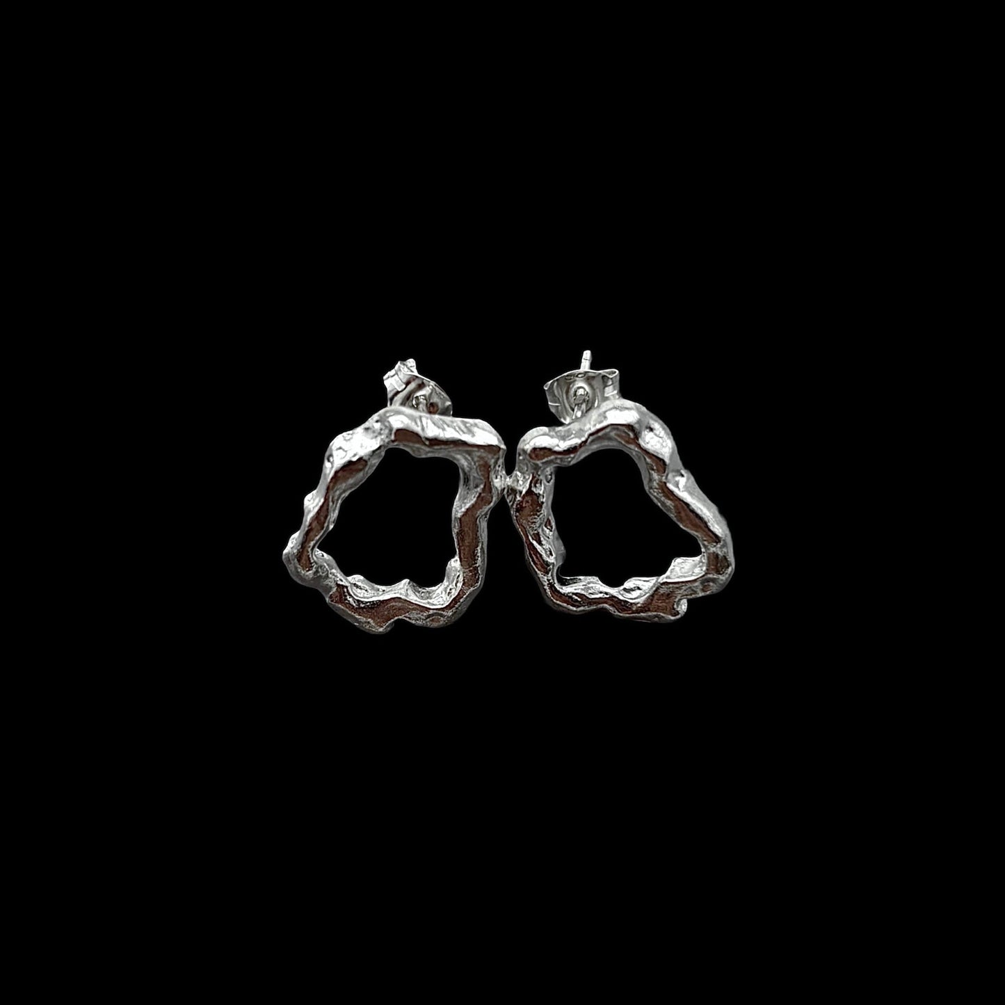 Silver hoop earrings on a black background
