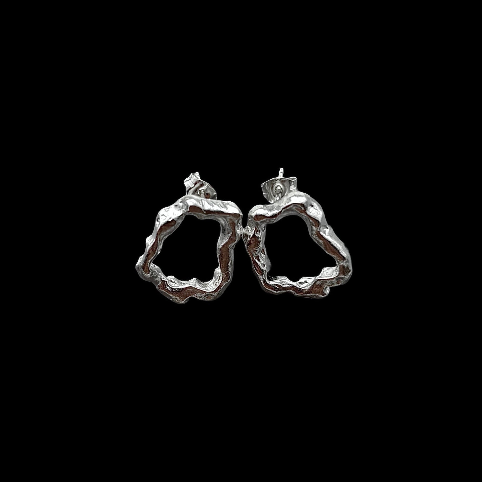 Silver hoop earrings on a black background